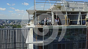 Aerial View Of Construction Site With Team Of Builders On Roof Discussing Plan Of Project