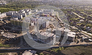 Aerial view of the construction site and yellow cranes. new apartment building in progress