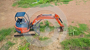 Aerial view of Construction tractor car, bulldozer, or backhoe digging road or street in transportation and agriculture concept.