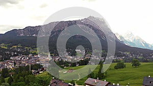 Aerial view of Cortina d`Ampezzo, panoramic view with alpine green landscape and massive Dolomites Alps. View of houses and hotels