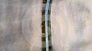 Aerial view of a country road amid fields spring.