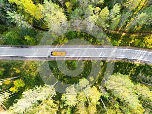 Aerial view of a country road in the forest with moving cars. Beautiful landscape. Captured from above with a drone. Aerial bird`