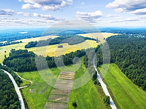 Aerial view of a country road in the forest with moving cars. Landscape. Captured from above with a drone. Aerial bird`s eye road