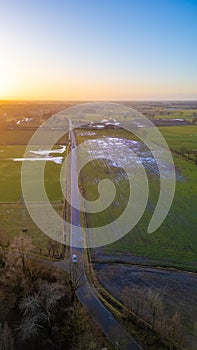 Aerial View of Country Road at Sunset with Luminous Fields