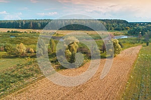 Arable field and brook on a summer sunny day. Aerial view.