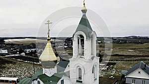 Aerial view of the countryside region with small houses and newly built orthodox church. Clip. Living in village.