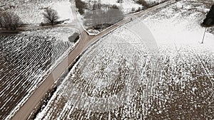 Aerial view with countryside road and snow covered plowed agriculture fields