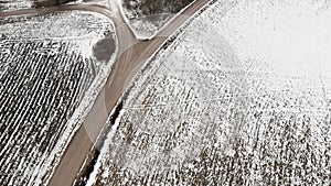 Aerial view with countryside road and snow covered plowed agriculture fields