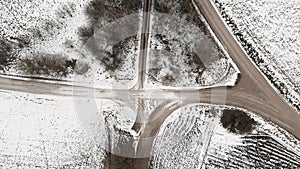 Aerial view with countryside road and snow covered plowed agriculture fields