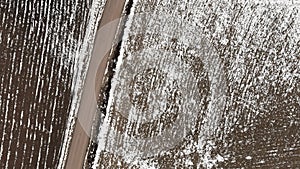 Aerial view with countryside road and snow covered plowed agriculture fields