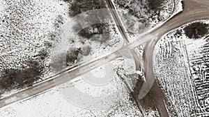Aerial view with countryside road and snow covered plowed agriculture fields