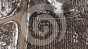 Aerial view with countryside road and snow covered plowed agriculture fields