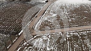 Aerial view with countryside road and snow covered plowed agriculture fields