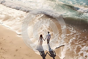 aerial view on the couple walking on the beach.