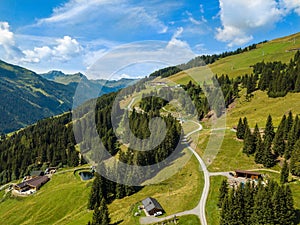 Aerial view on cozy hut and mountain in the skiing region of Hinterglemm in the Alps in Austria on a sunny summer day