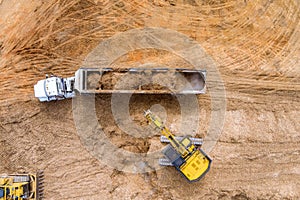 Aerial view at a crawler excavator digging soil excavating moving earth