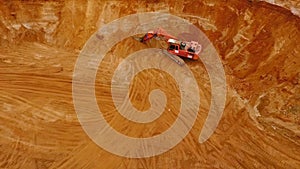 Aerial view of crawler excavator standing on sand mine. Sand mining