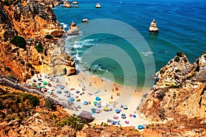 Aerial view of crowded Camilo beach in Lagos, Algrave, Portugal during the sunny day