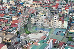 Aerial view of crowded resident houses in Chuong Duong Do, Hoan Kiem district, Hanoi, Vietnam. A tennis court staying among the ho