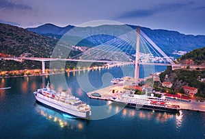 Aerial view of cruise ship at harbor and bridge at night