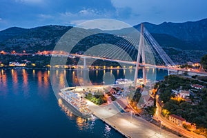 Aerial view of cruise ship at harbor and bridge at night