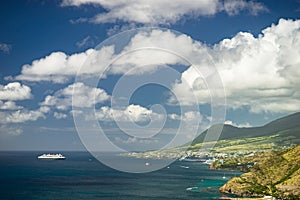 Aerial view of cruise ship near Caribbean island with green mountains photo
