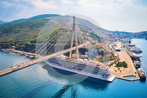 Aerial view of cruise ship under beautiful bridge at sunset