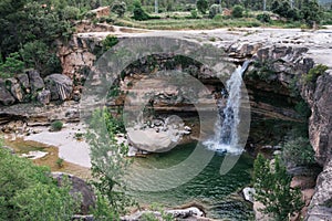 Aerial view of a crystal clear pool of a river with a large waterfall