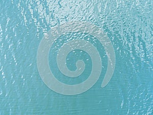 Aerial view of a Crystal clear sea water texture. View from above Natural blue background. Turquoise ripple water reflection in tr