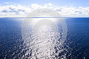 Aerial view of a crystal clear sea water texture. View from above Natural blue background. Blue water reflection. Blue ocean wave.