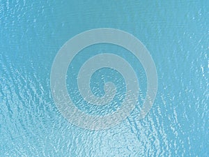 Aerial view of a Crystal clear sea water texture. View from above Natural blue background. Turquoise ripple water reflection in tr