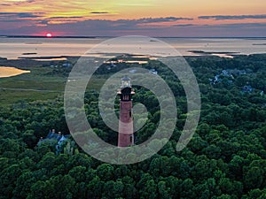 Aerial view of Currituck Beach Lighthouse on an island surrounded by lush green trees