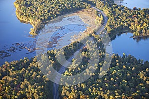 Aerial view of curving road between lakes and trees in autumn color in northern Minnesota