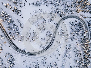 Aerial view of Curvy Windy Road in snow covered forest in Winter Finland