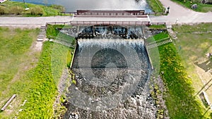 aerial view on dam lock sluice on river impetuous waterfall.