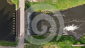 aerial view on dam lock sluice on river impetuous waterfall.