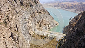 Aerial view of the dam at the mountain reservoir. Rocky mountains, hills and slopes of Kyrgyzstan