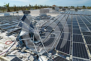 Aerial view of damaged by hurricane wind photovoltaic solar panels mounted on industrial building roof for producing