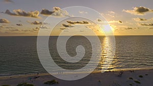 Aerial view of dark silhouettes of people enjoying sunset view over summser sea