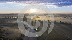 Aerial view of the dawn over the field in the fog