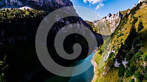 Aerial view of deep blue mountain lake in swiss alps with house, switzerland