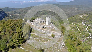 Aerial view of defense tower. The white stone fortress is located on the top of the mountain. It is illuminated by