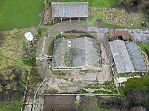 Aerial view of derelict farm buildings including hay barns and cow milking parlours.
