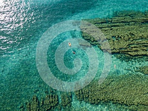 Aerial view of a dinghy in the water floating on a transparent sea. Bathers at sea. Zambrone, Calabria, Italy