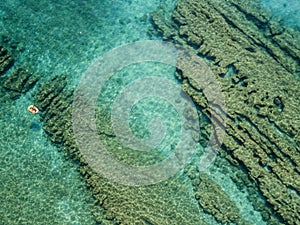 Aerial view of a dinghy in the water floating on a transparent sea. Bathers at sea. Zambrone, Calabria, Italy photo