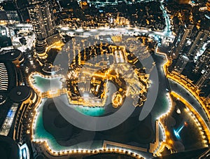 Aerial view of Downtown Dubai with roads, Dubai Mall and the fountain by night, from Burj Khalifa observatory deck in