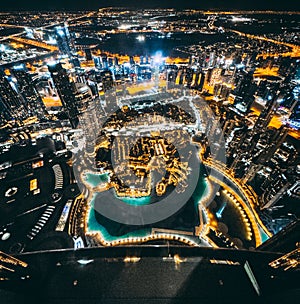 Aerial view of Downtown Dubai with roads, Dubai Mall and the fountain by night, from Burj Khalifa observatory deck in