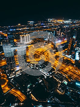 Aerial view of Downtown Dubai with roads, Dubai Mall and the fountain by night, from Burj Khalifa observatory deck in