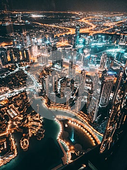 Aerial view of Downtown Dubai with roads, Dubai Mall and the fountain by night, from Burj Khalifa observatory deck in