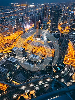 Aerial view of Downtown Dubai with roads, Dubai Mall and the fountain by night, from Burj Khalifa observatory deck in